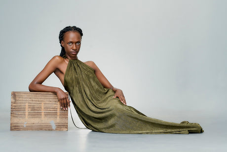 A woman in a green dress sitting on a box